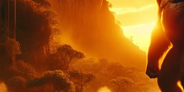 A massive King Kong stands majestically in a lush jungle, as an adventurous film crew approaches cautiously.